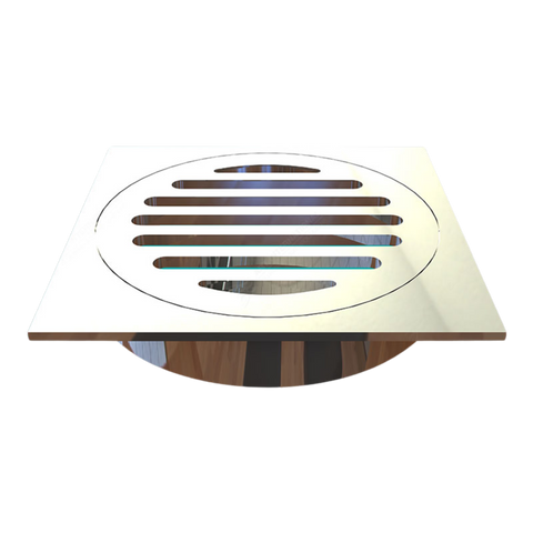 Square stainless steel shower drain grate with circular slotted bars, modern chrome finish on wood floor.