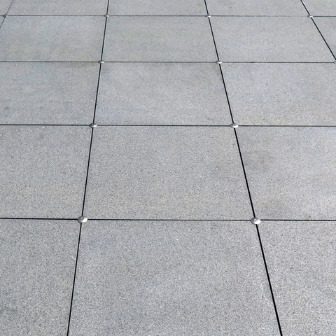 Gray square concrete pavers in grid pattern, textured surface for durable outdoor patio flooring.