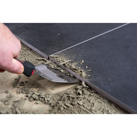 DTA Heavy Duty Wall Scraper removing old grout from tiles, prepping joints for polyurethane sealant application.