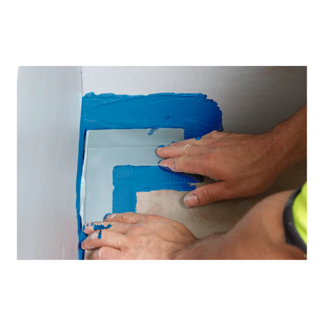 Installer embedding Gripset Elastoproof Prefabricated Corner into wet waterproofing membrane at wall-floor junction for se...